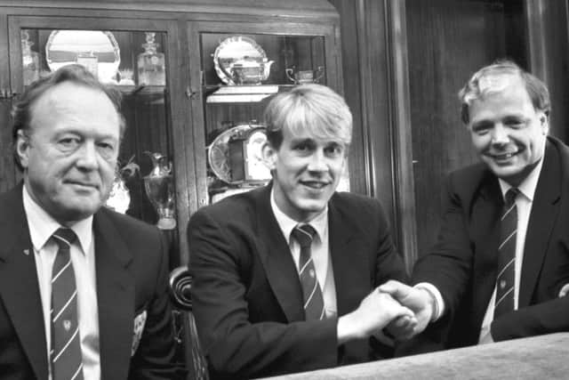 Hearts director Pilmar Smith, left, looks on as Gary Mackay shakes hands with chairman Wallace Mercer after extending his contract in 1987