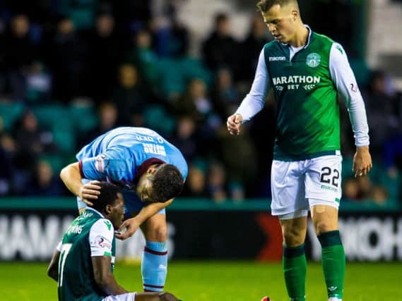 Hibs Thomas Agyepong cuts a dejected figure as he goes down injured. Pic: SNS