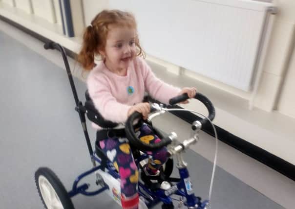 Sophie Fuller,4, on her adapted tricycle in November after her stroke. Picture: SWNS
