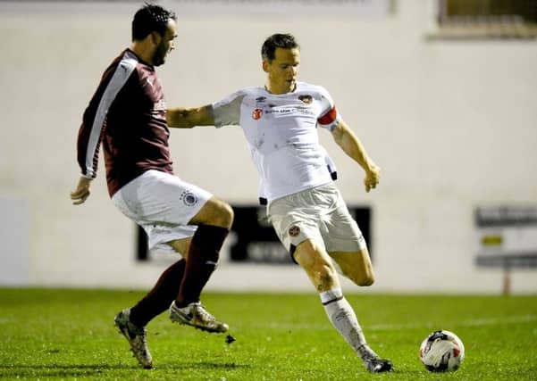 Hearts captain Christophe Berra clears the ball as Linlithgow striker Tommy Coyne closes in. Pic: Michael Gillen