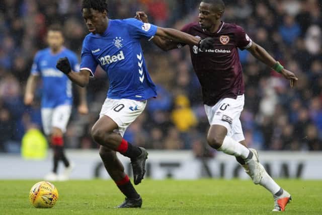 Arnaud Djoum, right, chases after Ovie Ejaria during Hearts' 3-1 defeat at Ibrox. Picture: SNS