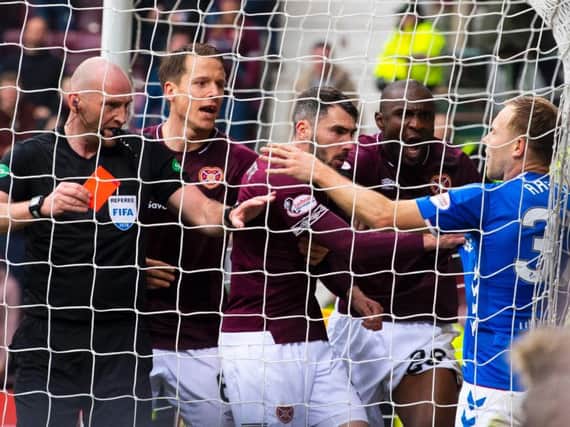 Referee Bobby Madden brandishes the red card at Rangers' Scott Arfield after his challenge on the Hearts goalkeeper Zdenek Zlamal.
