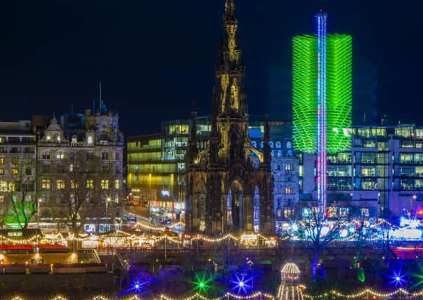 A long exposure photograph captures Scott Monument along side the 60 metre high Sky Flyer fairground ride which lights up Edinburgh's Christmas skyline in Princes Street Gardens. Picture: SWNS