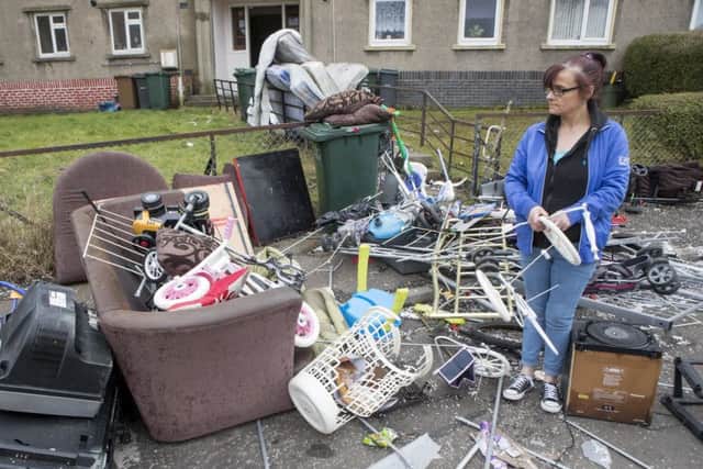 Mother-of-nine Donna Newby with the remains of her property which was dumped in garden in front of her flat when she came home to find she had been evicted. Picture: SWNS