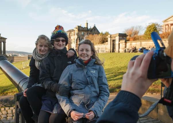 Tourists enjoy the view from Calton Hill, Edinburgh, which will be closed to the public at New Year. Pic: Toby Williams