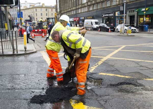 Workmen repair a pothole on Lothian Road. Picture: Ian Rutherford