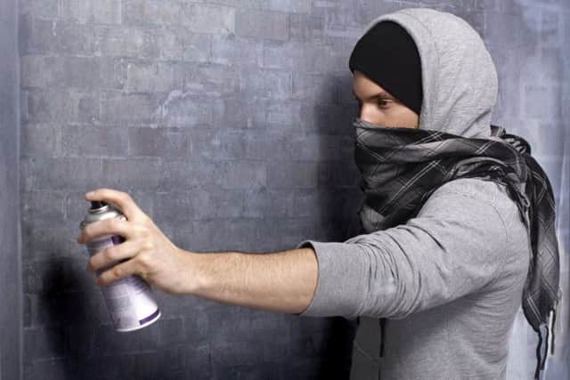 Hooded man spraying graffiti. Pic: Shutterstock