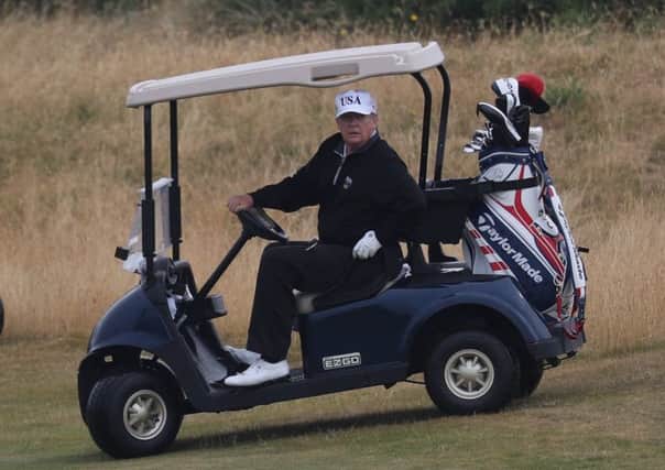 US President Donald Trump drives a golf buggy on his golf course at the Trump Turnberry resort in South Ayrshire last year. Pic: Andrew Milligan/PA Wire