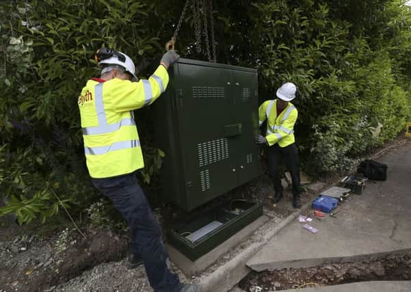 Openreach engineers installing one of the new fibre street cabinets.