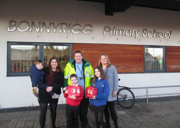 Sarah Beck with her son Robbie in arms, David Booth Linlithgow first responder, Bonnyrigg Primary School headteacher Jennifer Allison and  Sarah's other two  children Matt (P3) & Lucy (P7) in front.