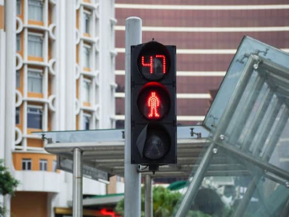 Pedestrian traffic light with countdown timer with a background of modern buildings. Pic: Shutterstock