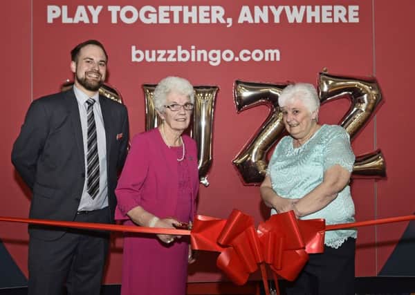 Isabella cuts the ribbon at Buzz, flanked by manager Ian Thayre and daughter Ann De Placido
