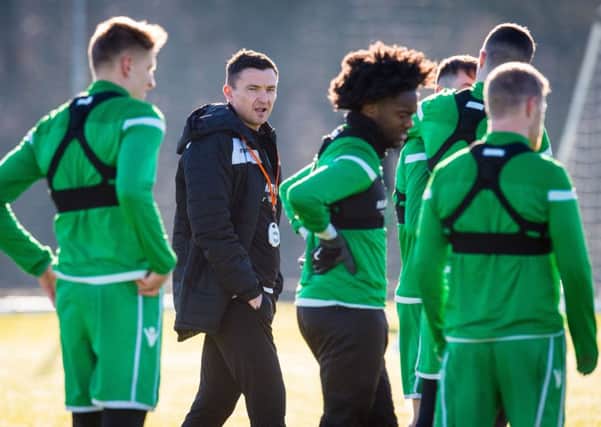 Paul Heckingbottom keeps tabs on his Hibs player during training. The new boss will make his bow today against Hamilton