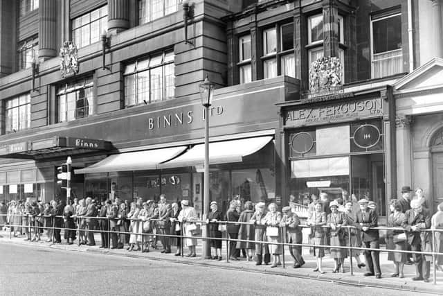 Traffic lights system at West End Edinburgh - People watch new system from barrier in Princes Street. Shops in the background are Binns and Alex Ferguson.