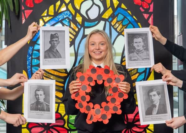 Ashley Fitzgerald in front of a stain glass window designed by the pupils with portraits of former pupils who died during World War One.