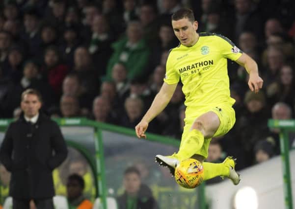 Paul Hanlon controls the ball in the air as former Celtic manager, Brendan Rodgers, looks on at Celtic Park