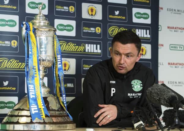 Paul Heckingbottom takes an admiring glance at the Scottish Cup as he briefs the media at Easter Road