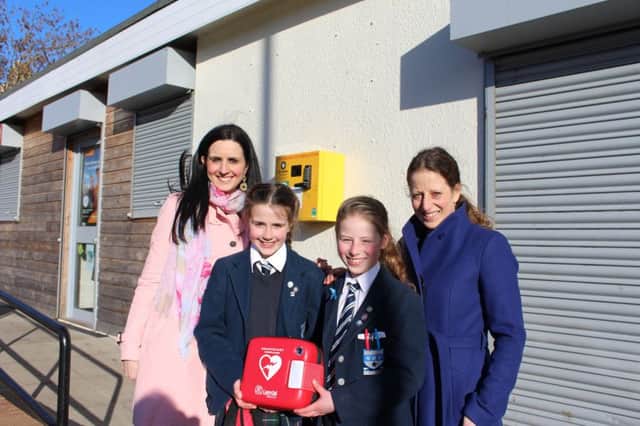 Two 10-year old school friends unveil a defibrillator at the Meadows Pavilion that they fundraised for at the end of last year.

Pic captions: 
Lily MacRae (dark hair) Isla Hathorn (blonde) 

With mums: Alison MacRae (black hair, pink coat), Claire Hathorn (purple coat)