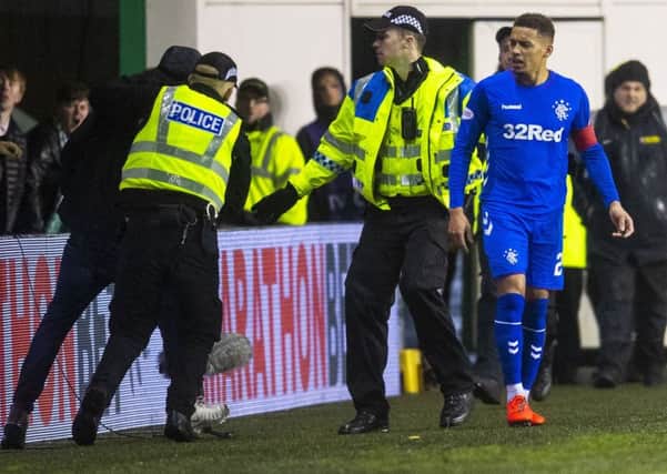 The police grapple with the intruder as James Tavernier looks on