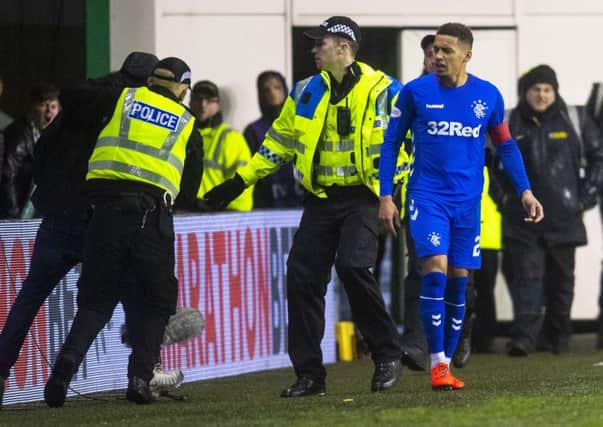 Police lead a supporter away after he confronted Rangers captain James Tavernier on Friday night