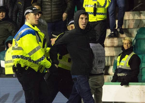 Mack being lead away by police after running onto the park and confronting James Tavernier