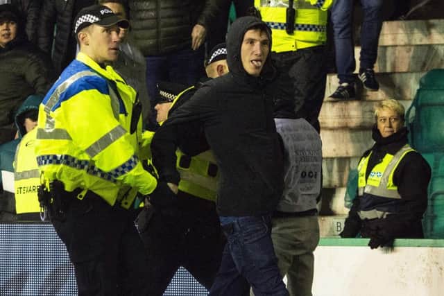 Mack being lead away by police after running onto the park and confronting James Tavernier