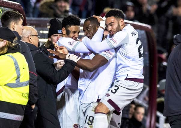 Uche Ikpeazu (centre) celebrates with the dugout after equalising for Hearts