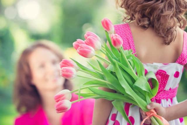 A woman and child with a bouquet of flowers. Pic: Sunny Studio/Shutterstock
