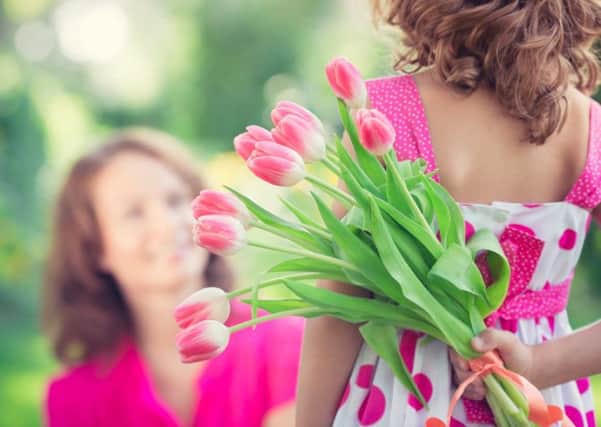 A woman and child with a bouquet of flowers. Pic: Sunny Studio/Shutterstock