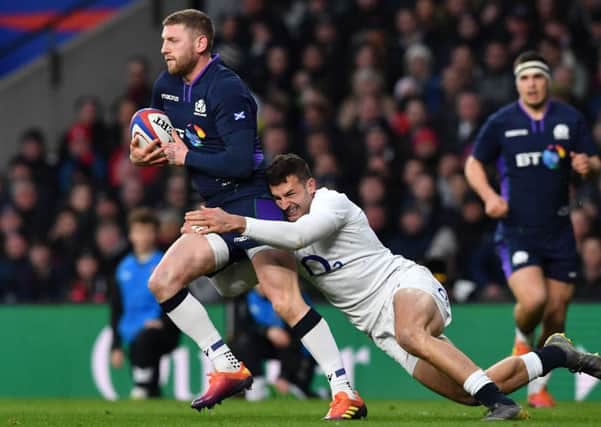 Finn Russell is tackled by England wing Jonny May. Picture: AFP/Getty Images