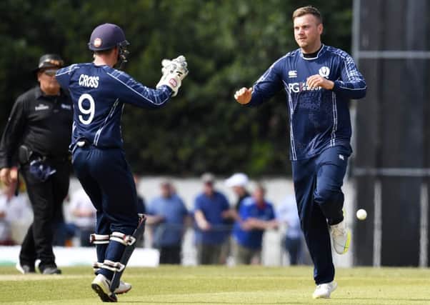 Mark Watt, right, celebrates a wicket against England with Matthew Cross. Picture: SNS Group