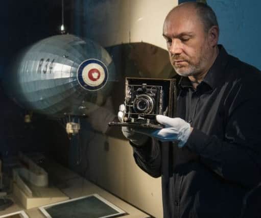 Ian Brown, Assistant Curator of Aviation at the National Museum of Flight, East Fortune, East Lothian with a  camera used on the R.34 airship's record-breaking transatlantic flight. Pic: Phil Wilkinson