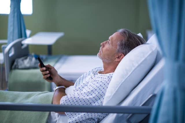 Patient watching television on bed at the hospital.