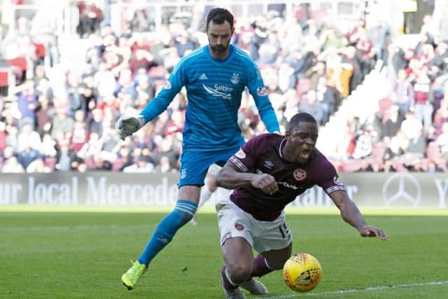 Uche Ikpeazu goes down under the challenge from Aberdeen's Joe Lewis but was booked for diving. Picture: SNS Group