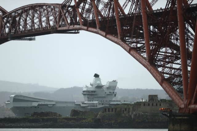 The 65,000 tonne HMS Queen Elizabeth Aircraft carrier goes under the Forth Bridge. Picture: Katielee Arrowsmith/SNWS