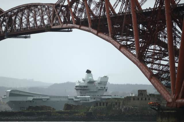 The 65,000 tonne HMS Queen Elizabeth Aircraft carrier goes under the Forth Rail Bridge
