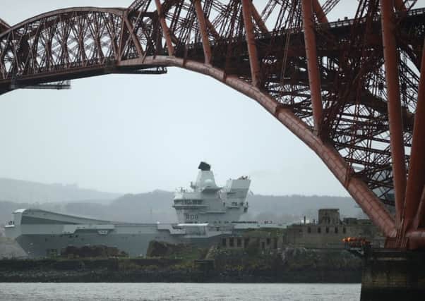The 65,000 tonne HMS Queen Elizabeth Aircraft carrier goes under the Forth Rail Bridge