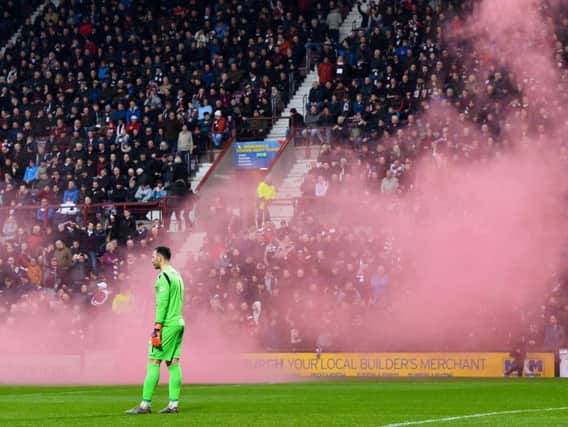 Both fans set off flares during the Hearts-Hibs match. Pic: SNS