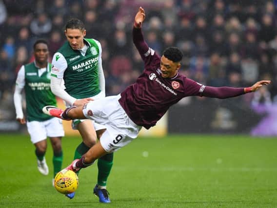 Hibs' Mark Milligan tangles with Hearts' Sean Clare. Pic: SNS