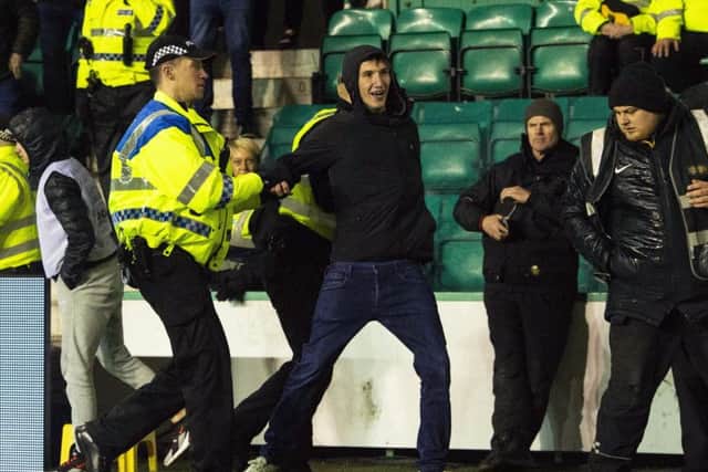 Cameron Mack is led away by Police after running onto the pitch