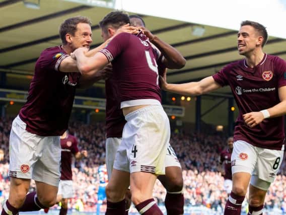 John Souttar is mobbed by his team-mates after scoring Hearts' second goal. Pic: SNS