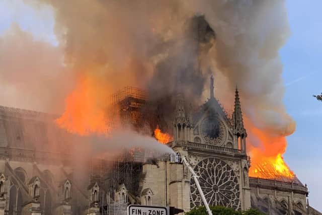 Flames and smoke are seen billowing from the roof at Notre-Dame Cathedral in Paris on April 15, 2019. (Photo by Patrick ANIDJAR / AFP)