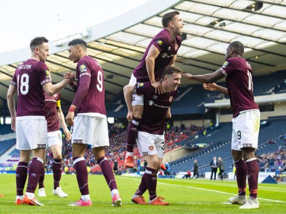 Hearts' Sean Clare shakes hands with Steven MacLean, as Olly Lee celebrates with Bobby Burns and Uche Ikpeazu