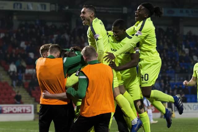 Hibernian's Mark Milligan celebrates with scorer Marc McNulty after making it 2-1 against St Johnstone at McDiarmid Park. Picture: TSPL