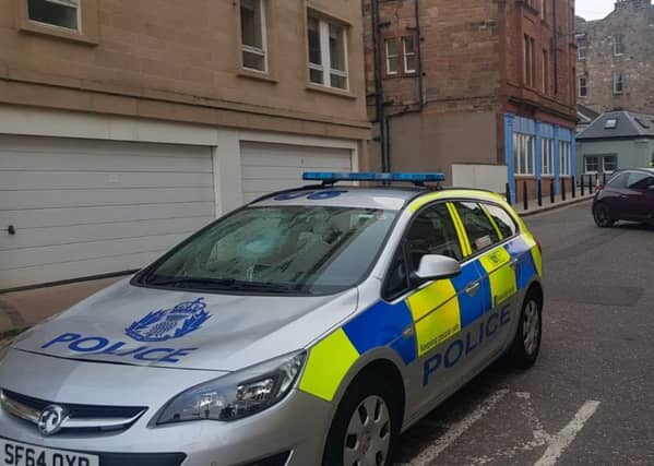 The image shows a police car with its front window smashed and a dent to the bonnet. Pic: contributed