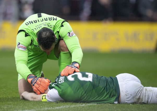 Ofir Marciano checks on the welfare of David Gray during the last derby. Pic: SNS