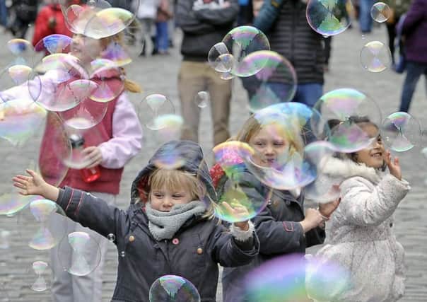 Children play with bubbles on the road during the Open Streets event earlier this month. Picture: Neil Hanna