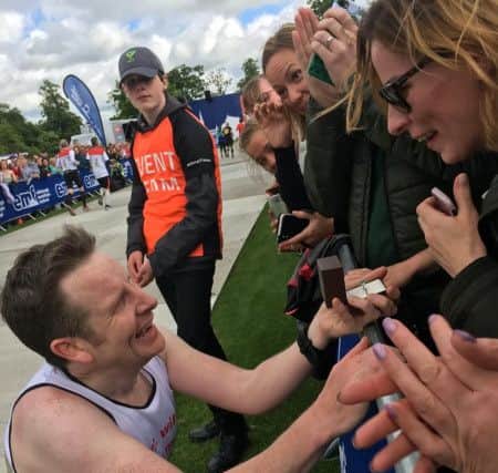 The emotional moment that marathon runner Jonny Black, 43, proposed to partner Kathryn Keir, 41, at the end of this weekends Edinburgh Marathon. Jonny Black - SWNS