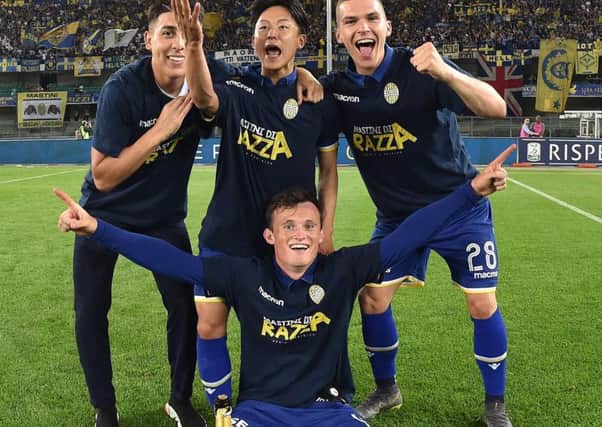 Liam Henderson (centre, bottom) celebrates with his Verona team-mates after winning promotion to Italy's Serie A