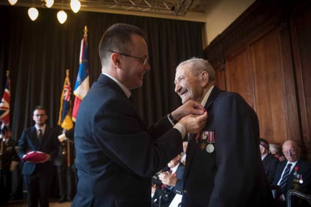 D-Day veteran David Duguid receives his Lgion dHonneur Cross from Emmanuel Cocher, the French Consul General.